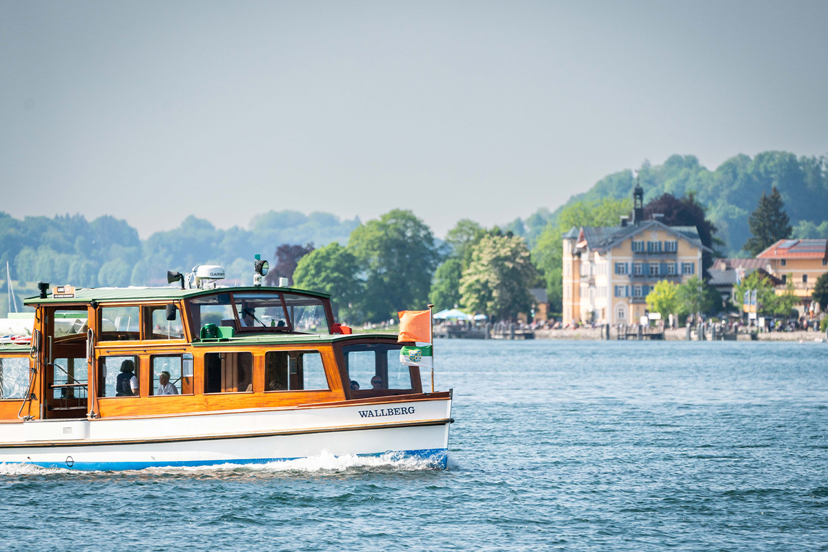 Ein Boot fährt auf einem See von links nach rechts