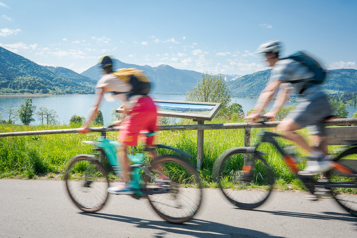 Foto von zwei Radfahrern die an einem Seeufer fahren