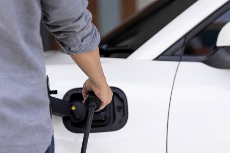 E-Auto wird gerade geladen von einer Person