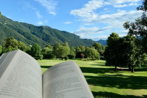 Blick ins Grüne mit einem Buch von der Terrasse des Gästehaus Florian